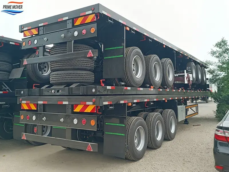 Tri-axle flatbed semi-trailer with a black chassis and a 40-ton carrying capacity